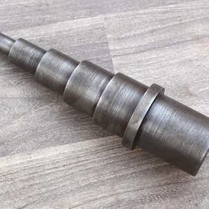 Può includere: Una tazza di ceramica bianca con manico nero e la scritta "But First, Coffee" in nero, con un carattere a mano. La tazza è su una superficie bianca.