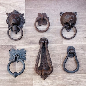 Puede incluir: Seis estilos diferentes de llamadores de puerta de hierro fundido. Los llamadores están en varias formas, incluyendo una cabeza de león, una cabeza de oso y un óvalo simple. Los llamadores son todos negros y tienen un acabado rústico.