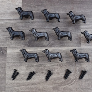 May include: Ten black cast iron dachshund drawer pulls with screws. The pulls are in the shape of a dachshund dog.