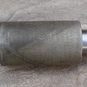 Könnte beinhalten: Nahaufnahme einer silbernen Langhantel mit einer strukturierten, geriffelten Hülse. Die Hülse ist so konzipiert, dass sie beim Gewichtheben einen sicheren Griff bietet.