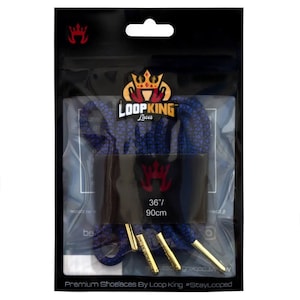 Puede incluir: Un par de cordones azules y negros con terminales dorados. Los cordones están empaquetados en una bolsa de plástico transparente con una tarjeta de encabezado negra que dice "LOOPKING Laces" y presenta un logotipo de corona. La tarjeta de encabezado también incluye el texto "36"/ 90cm".
