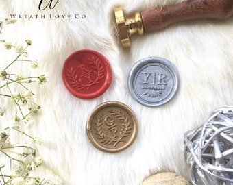 May include: Three wax seals with different initials and dates. The seals are red, silver, and gold. The seals are on a white fuzzy surface.