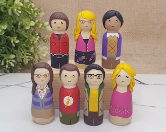 May include: Set of seven hand-painted wooden peg dolls, each depicting a different character. The dolls are dressed in various colorful outfits, including a red shirt, a pink dress, a purple sweater, and a yellow jacket.