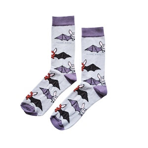 May include: A pair of light grey socks with a purple cuff, heel, and toe. The socks feature a repeating pattern of cartoon bats in black, red, and purple. The text "BARE KIND" is printed on the socks.