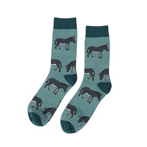 Op de afbeelding: Een paar sokken met een teal achtergrond en een patroon van donkergrijze ezels. De sokken hebben donker teal hielen en tenen, en donker teal manchetten. De merknaam staat op de zijkant van één sok.