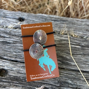 May include: Two silver hair ties with a geometric design on a brown card with the text "TombstoneCowboyCo.Etsy.com" and "Follow us on Instagram TombstoneCowboyCo".