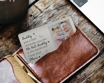 May include: A silver wallet card with a photo of a father and daughter. The card has a message that reads "Daddy. Just a little reminder you are the best daddy in the world and I love you! Olivia."