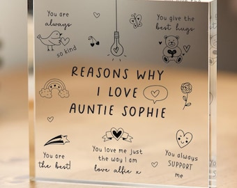 May include: A clear acrylic block with the text "Reasons why I love Auntie Sophie" and several illustrations including a bird, a lightbulb, a rainbow, a flower, a teddy bear, a star, a heart, and a speech bubble. The text "You are always so kind", "You give the best hugs", "You are the best", "You love me just the way I am love alfie x", and "You always support me" are also included.
