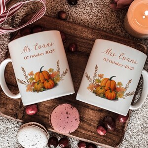 Peut inclure: Deux tasses en céramique blanche sur le thème de l'automne. Les tasses présentent un motif de citrouilles, de feuilles et d'épis de blé. Le texte sur les tasses est "Mr. Evans 07 octobre 2023" et "Mrs. Evans 07 octobre 2023".