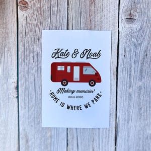 May include: A white card with the names "Kate & Noah" above a red camper van illustration. Below the van, the text reads "Making memories!" and "Home is where we park." The year "since 2026" is also included.
