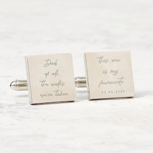 May include: A pair of silver square cufflinks. One cufflink reads "Dad of all the walks we've taken" in script. The other cufflink reads "this one is my favourite" with the date "29.09.2025" in script.