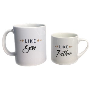 May include: Two white ceramic mugs with black text. The larger mug says "**LIKE** **Son**" and the smaller mug says "**LIKE** **Father**".