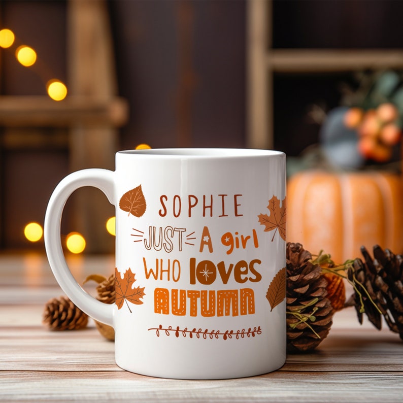 May include: White ceramic mug with a brown autumn-themed design. The mug has a handle and says "Sophie Just A Girl Who Loves Autumn" with fall leaves and a star.