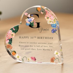 以下が含まれることがあります： 花柄の透明なハート型のガラス製ペーパーウェイトで、「Grace」と「HAPPY 30TH BIRTHDAY Cheers to another awesome year! Hope your day is full of love, fun, and good vibes. Love Martha x」の文字が書かれています。