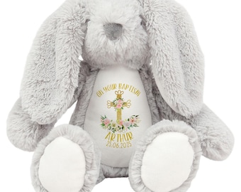 May include: A gray plush bunny with a white patch on its chest. The patch has a gold cross with floral accents and the text "On your Baptism Arthur 25.06.2025".