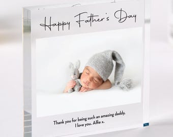 Puede incluir: Bloque acrílico transparente con una foto de un bebé durmiendo con un gorro de punto gris y un conejito de peluche. El texto "Happy Father's Day" está encima de la foto, con un mensaje debajo: "Thank you for being such an amazing daddy, I love you. Alfie x."