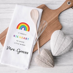 May include: White kitchen towel with a rainbow design and the text "It takes a big heart to shape little minds Mrs. Groves".