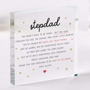 May include: A clear acrylic block with the word "stepdad" in black script. The block contains a heartfelt message with gold stars and a red heart. The message is a thank you from "Olivia".