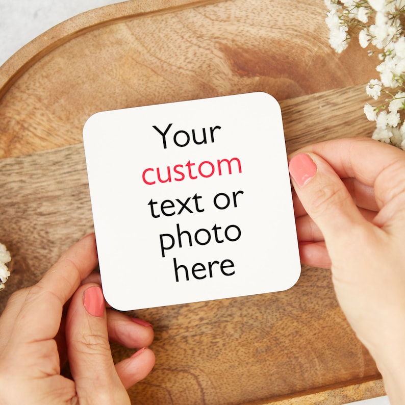 May include: White coaster with the text "Your custom text or photo here" in black lettering. The word "custom" is in red.