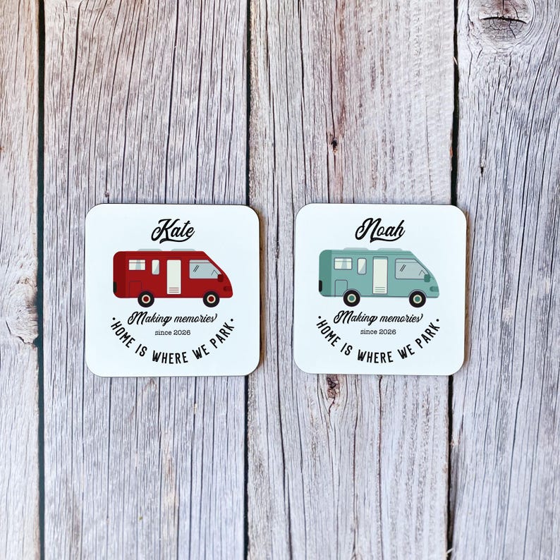 May include: Two square white coasters with rounded corners. One coaster features a red camper van design with the name "Kate" above it. The other coaster has a teal camper van design with the name "Noah". Both coasters have the text "Making memories since 2026. Home is where we park."