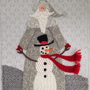 May include: A white snowman with a black top hat, red scarf, and orange carrot nose stands next to a gray-haired Santa Claus wearing a gray robe with white stars.