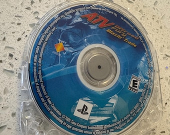 May include: A circular Universal Media Disc for the PlayStation Portable featuring the game ATV Offroad Fury Blazin' Trails. The disc label is blue with white text, the ESRB E rating symbol, the Sony logo, and the PlayStation logo.