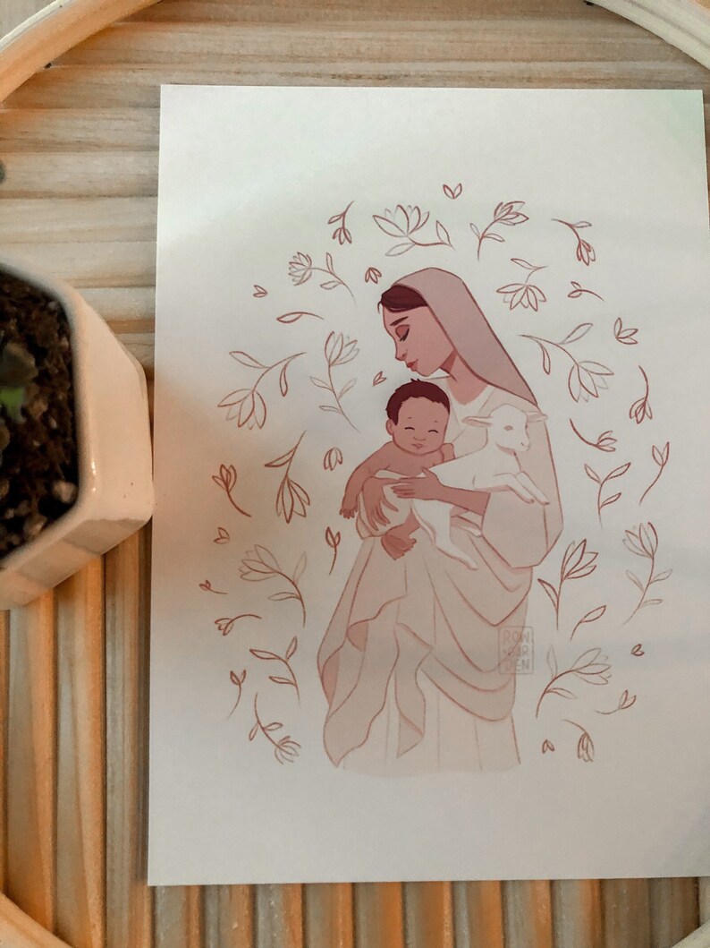 May include: A digital illustration of a woman holding a baby and a lamb. The woman is wearing a white robe and has dark hair. The baby is wearing a white cloth and has dark hair. The lamb is white and has a pink nose. The background is a light pink with a floral pattern.