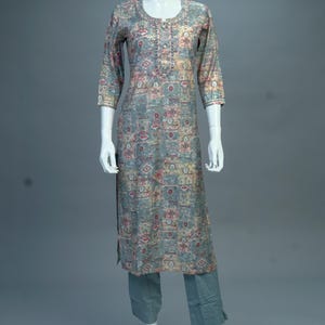 May include: A long-sleeved, patterned kurta with a round neckline and a button closure. The kurta is a light blue color with a multi-colored geometric pattern. The kurta is paired with matching pants.