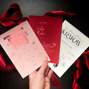 May include: Three event cards with red ribbon. The cards are pink, red, and white. The pink card says "Birthday Extravaganza London". The red card says "Valentine Weekend". The white card says "Our Winter Holiday in Krakow".