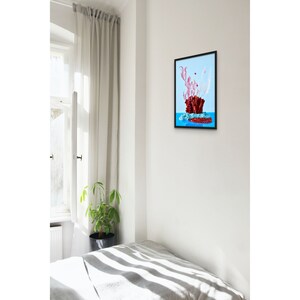Op de afbeelding: Een ingelijste print van een rood koraalachtig object met roze en witte accenten op een blauwe achtergrond.