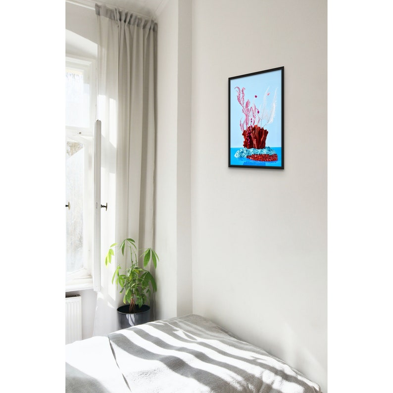 Op de afbeelding: Een ingelijste print van een rood koraalachtig object met roze en witte accenten op een blauwe achtergrond.