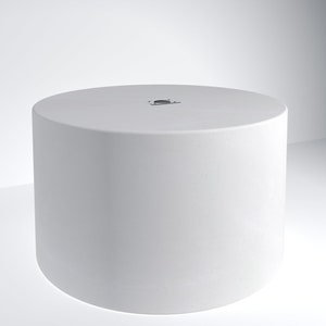 May include: White cylindrical platform with a small black circle in the center. The platform is on a white background.