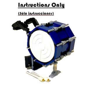 May include: A blue and white Lego drum set with the text "Instructions Only" above and "(Sólo instrucciones)" below. The drum has a white center and is supported by a clear stand. Two white drumsticks are in the foreground.