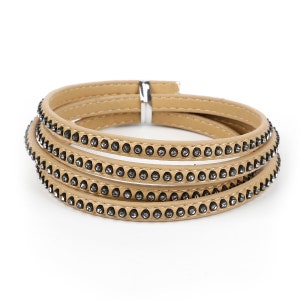 May include: A beige leather bracelet with four rows of rhinestones.