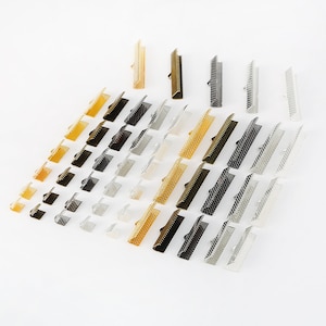 May include: Assortment of metal cord end caps in gold, silver, and black finishes. The caps are arranged in rows, with each row featuring a different finish.