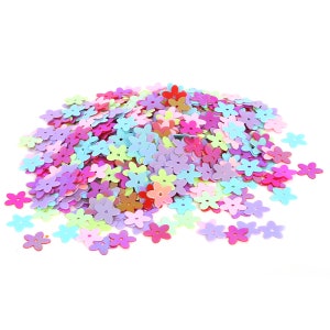 May include: A large pile of colorful flower-shaped sequins in various pastel shades, including pink, purple, blue, green, and yellow.