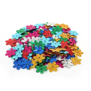 Op de afbeelding: Een stapel bloemvormige pailletten in verschillende kleuren, waaronder rood, blauw, groen, goud en zilver. De pailletten zijn verspreid op een witte achtergrond, waardoor een levendige en decoratieve weergave ontstaat. Ideaal voor knutselprojecten.