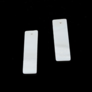 May include: Two rectangular, white pendants with a pearlescent sheen, each featuring a small hole at the top. The pendants are set against a stark black background, highlighting their smooth, polished surfaces. Ideal for jewelry making.