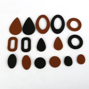 May include: Assortment of 15 wooden earring blanks in brown and black. The shapes include circles, ovals, teardrops, and rectangles.