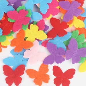 Puede incluir: Una colección de formas de mariposas de fieltro de colores, incluyendo rojo, naranja, amarillo, verde, azul, morado y rosa.