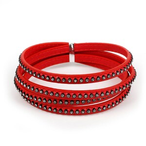 May include: A red leather bracelet with four layers and a row of rhinestones on each layer.