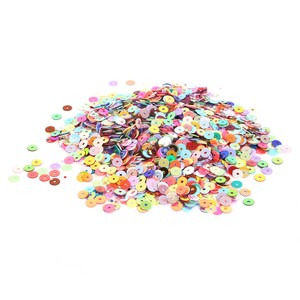 May include: A large pile of colorful iridescent sequins in various shades of pink, blue, green, yellow, orange, and red. The sequins are scattered on a white background.