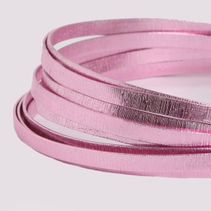 May include: Close-up of pink metallic wire, a craft supply, coiled and showing a textured surface.