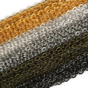 May include: Four different colors of chain, gold, silver, bronze, and black, are stacked on top of each other. The chains are all the same style, with oval links.