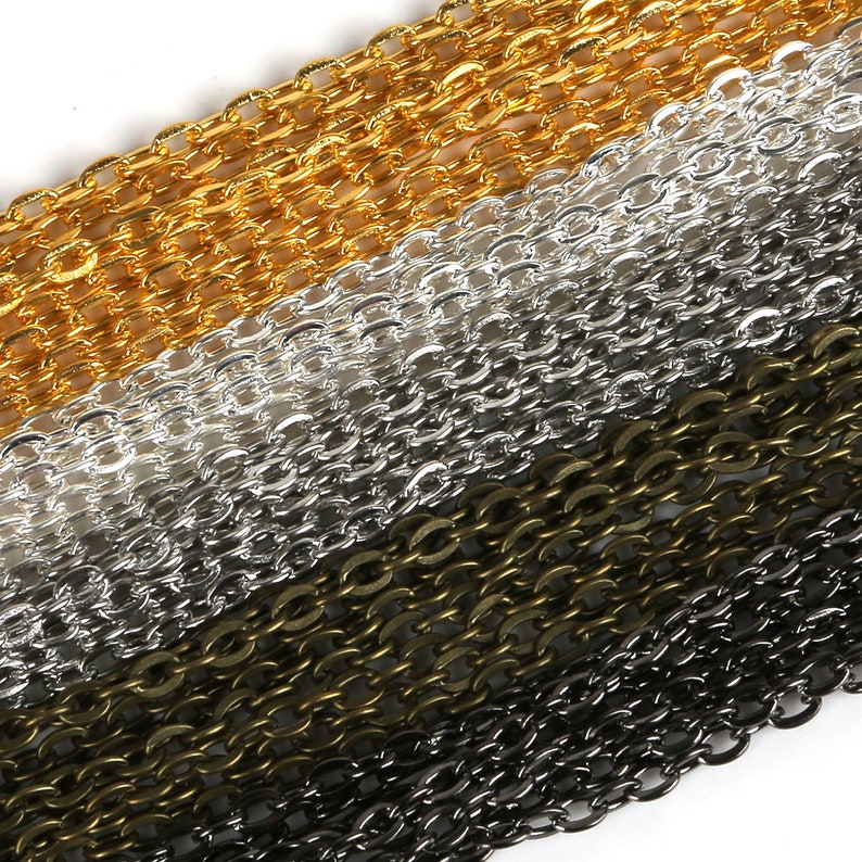 May include: Four different colors of chain, gold, silver, bronze, and black, are stacked on top of each other. The chains are all the same style, with oval links.