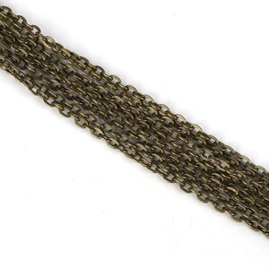May include: A close-up of a long strand of gold-toned chain. The chain is made of small, oval-shaped links.