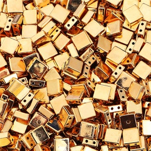 May include: A large pile of gold-colored metal beads. The beads are square shaped with small holes on each side.