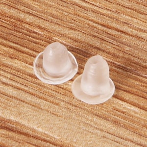 May include: Two clear plastic earring backs. The backs are designed to hold earrings in place.