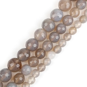 May include: A strand of grey agate beads with a faceted finish. The beads are round and have a smooth, polished surface.