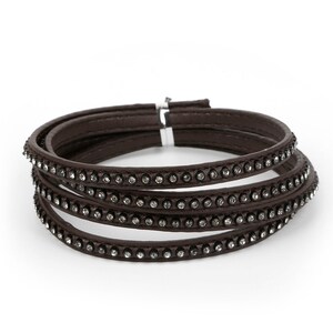 May include: A brown leather bracelet with four rows of clear rhinestones.